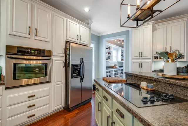 a kitchen with stainless steel appliances granite countertop a stove and a refrigerator