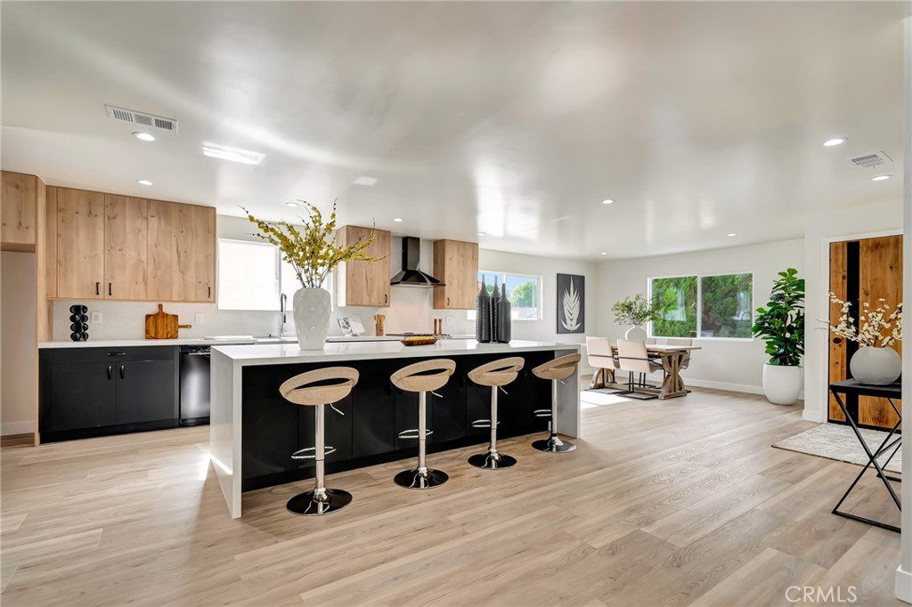 6512 Franrivers Avenue West Hills, CA 91307 - Photo 3 of 33 a open kitchen with granite countertop a stove a sink a dining table and chairs with wooden floor