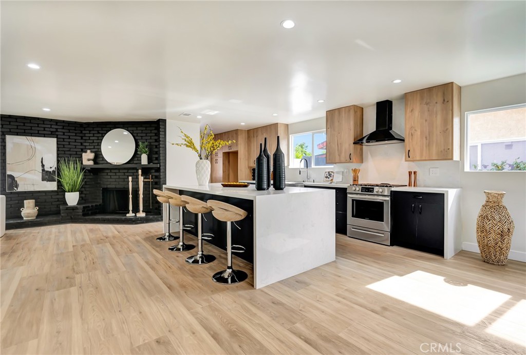 6512 Franrivers Avenue West Hills, CA 91307 - Photo 5 of 33 a large kitchen with stainless steel appliances a stove a sink dishwasher and a fireplace with wooden floor