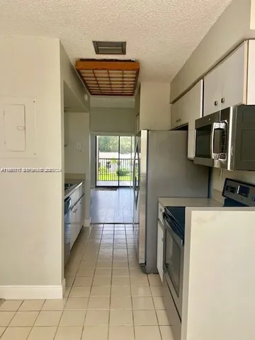 a kitchen with a refrigerator and a stove top oven
