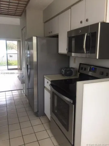 a kitchen with granite countertop a stove and a microwave