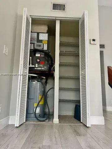 a view of a kitchen with stainless steel appliances wooden floor and a window