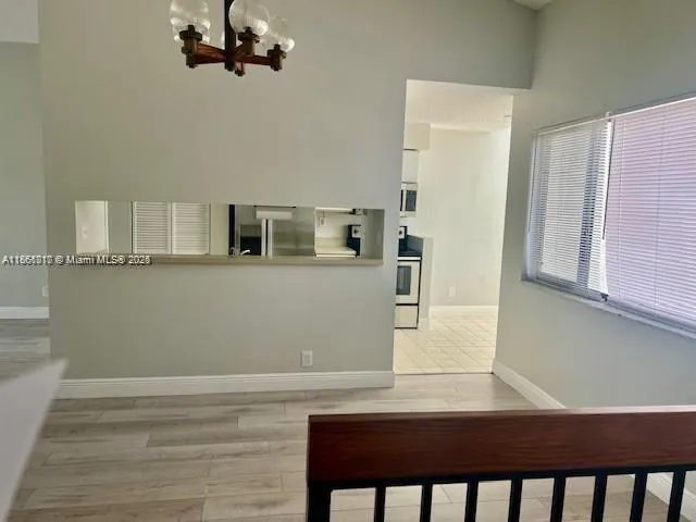 a view of a kitchen with stainless steel appliances granite countertop a refrigerator a stove and a wooden floors