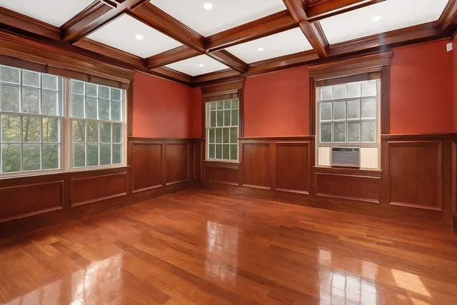 a view of an empty room with a window and wooden floor