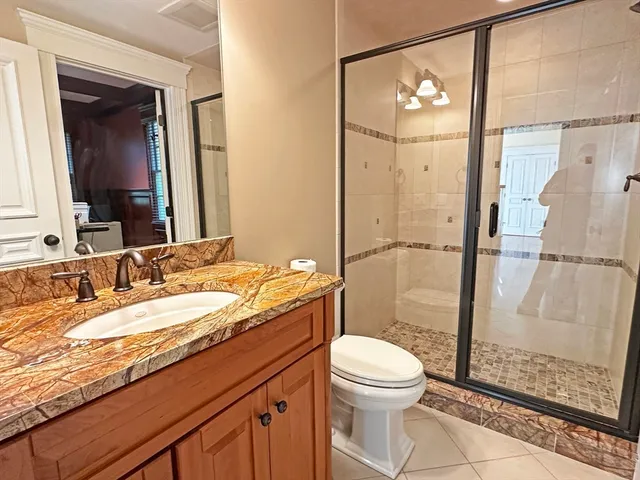 a bathroom with a granite countertop sink mirror vanity and toilet