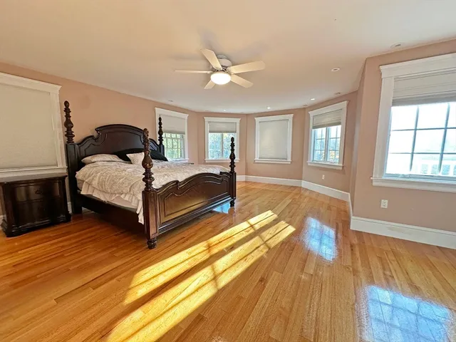 a spacious bedroom with a bed and wooden floor