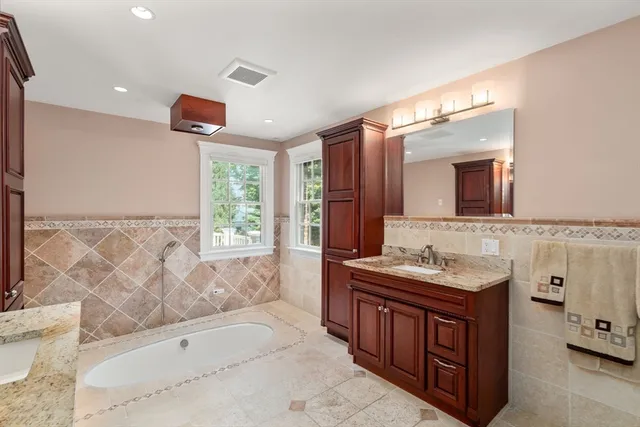 a bathroom with a tub sink and mirror