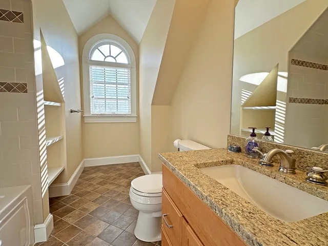 a bathroom with a granite countertop sink a mirror and a bathtub