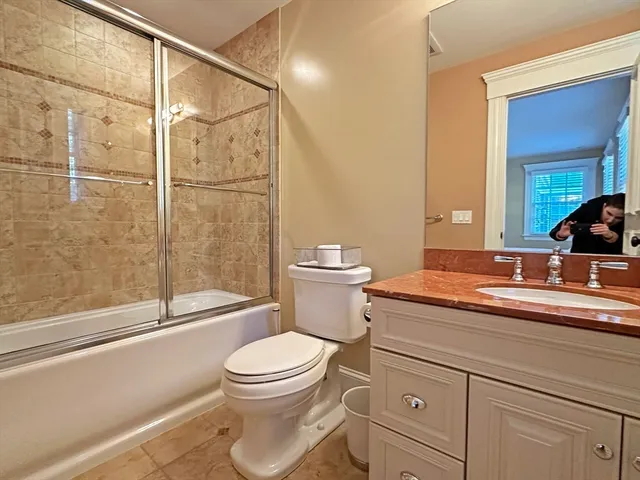 a bathroom with a granite countertop sink a toilet and shower