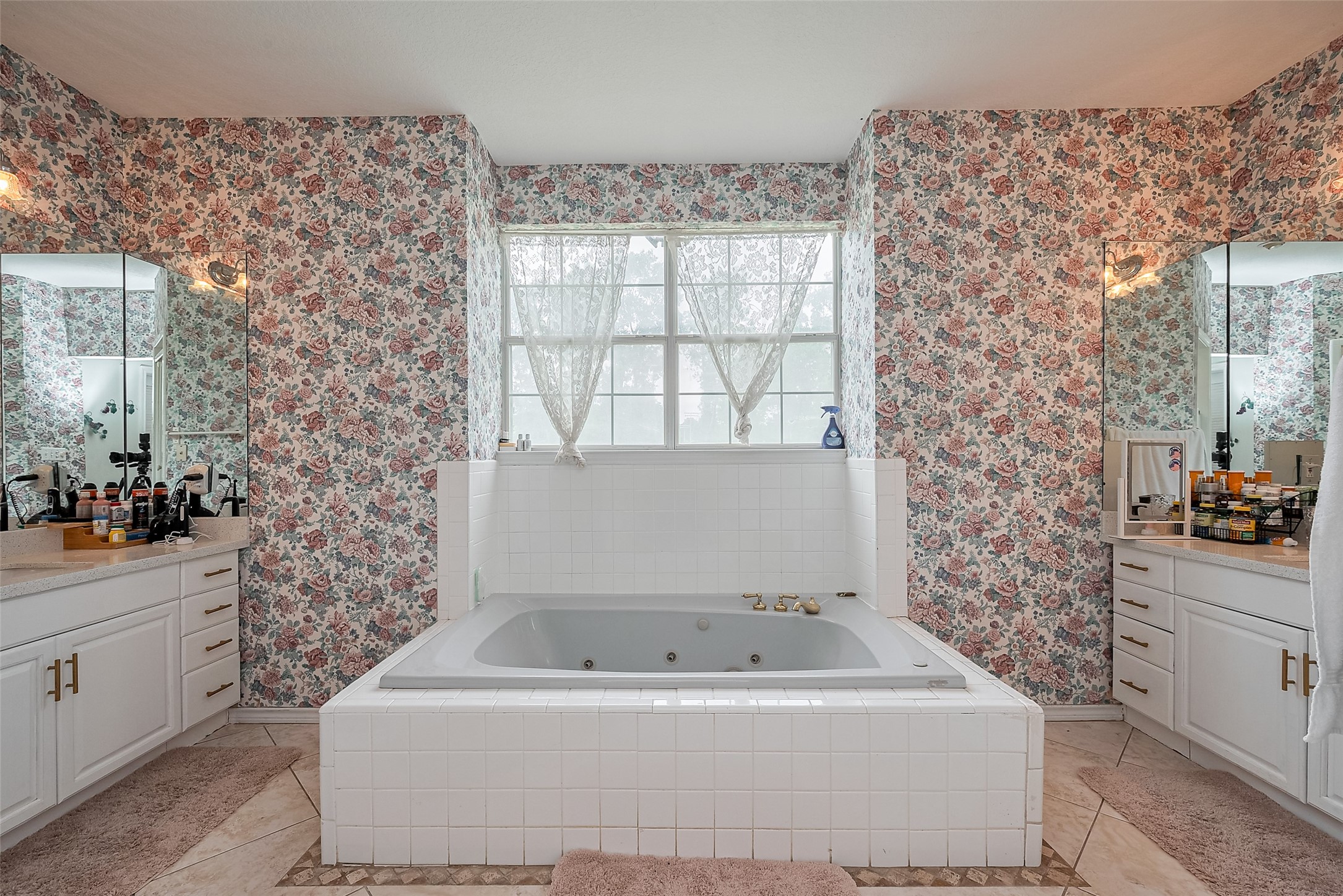 2499 Southline Road Conroe, TX 77384 - Photo 38 of 49 Primary bathroom featuring a large soaking tub, dual vanities, and natural light from the oversized window.