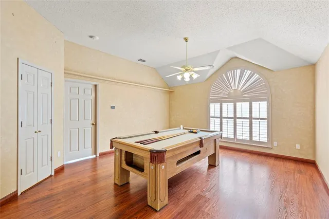 a room with wooden floor and ceiling fan