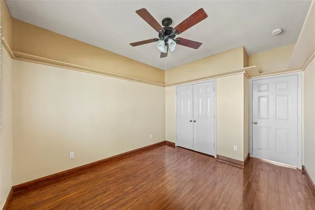 a view of a big room with wooden floor and a ceiling fan