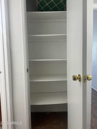 a view of walk in closet with empty racks