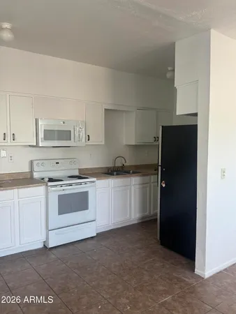a kitchen with a refrigerator stove and white cabinets