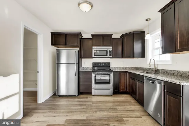 a kitchen with stainless steel appliances granite countertop a refrigerator stove and oven