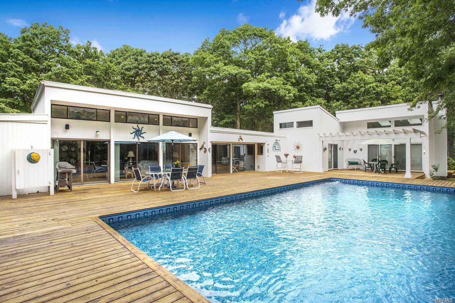 swimming pool view with a seating space and a garden view