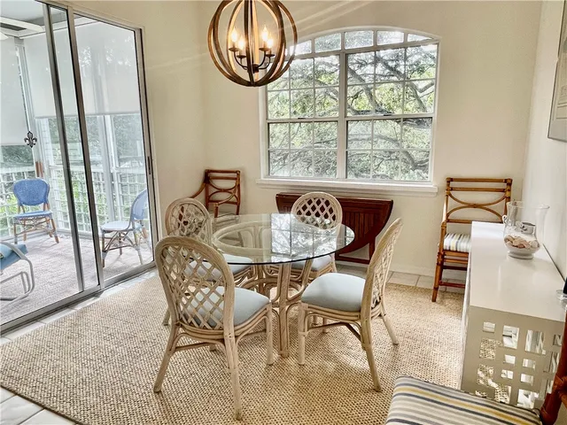 a view of the patio with dining table and chairs under an umbrella with a barbeque grill and couches