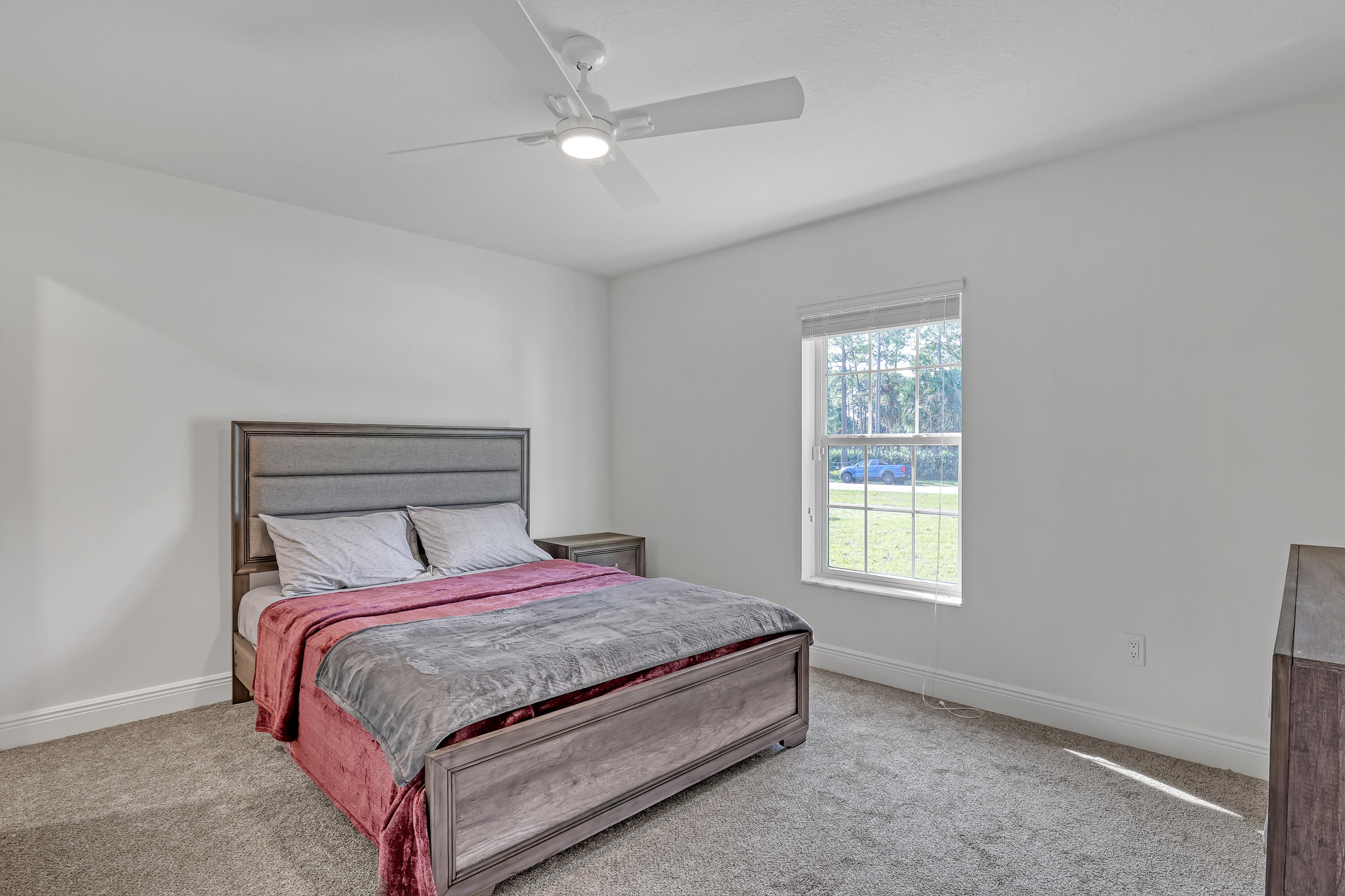 16775 Orange Boulevard Loxahatchee, FL 33470 - Photo 30 of 53 a bedroom with a bed two lamps and a window