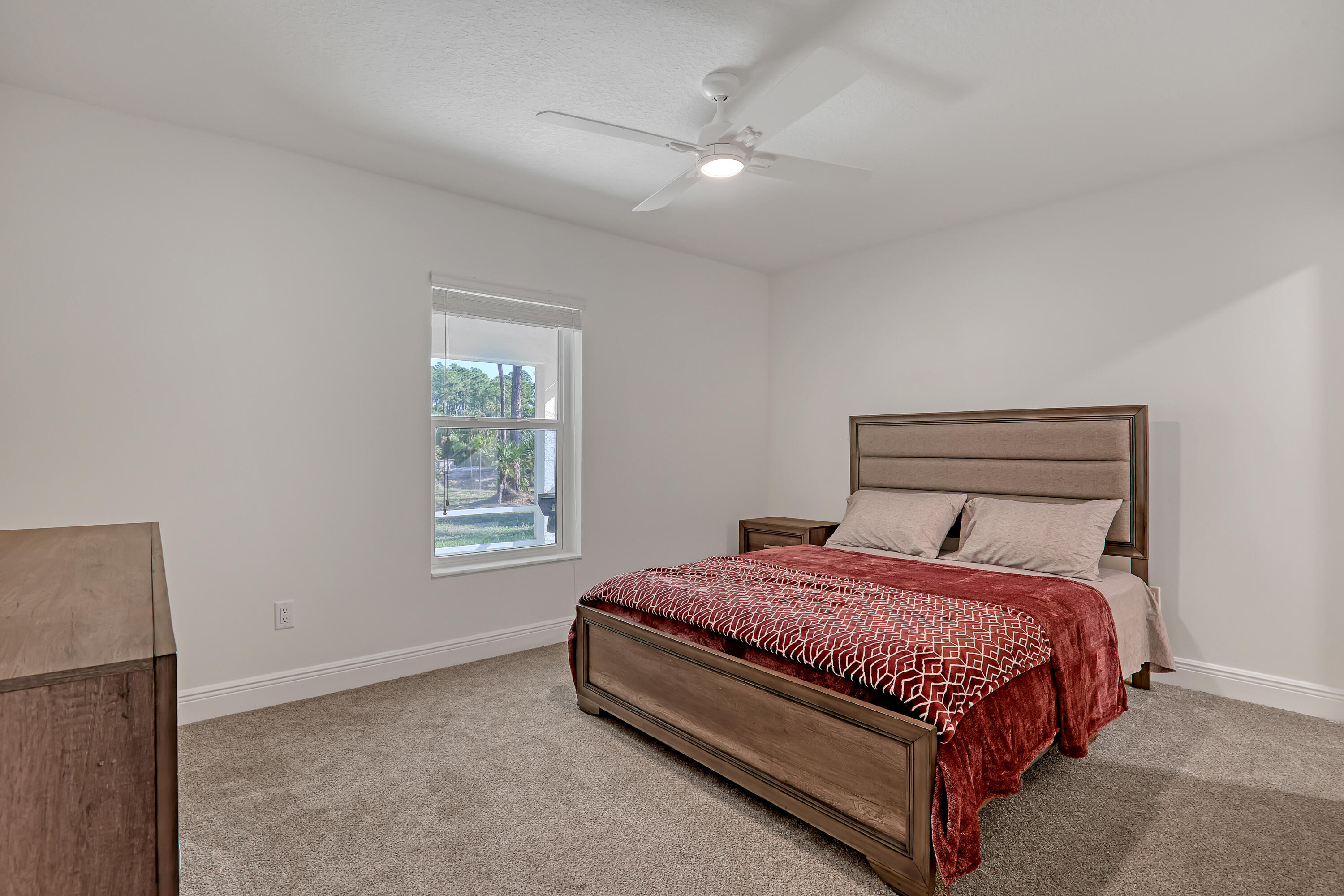 16775 Orange Boulevard Loxahatchee, FL 33470 - Photo 33 of 53 a bed sitting in a bedroom next to a window