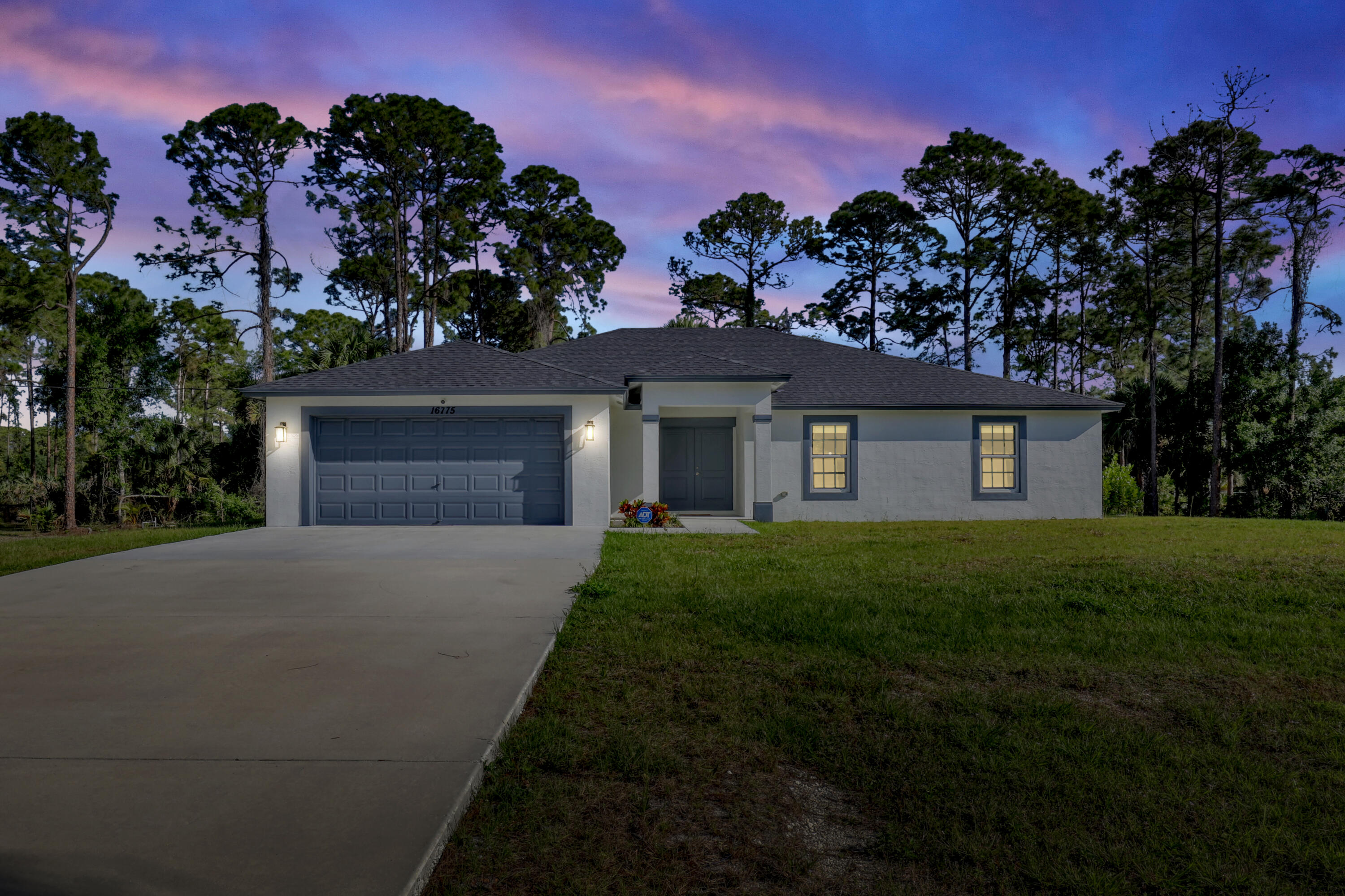 16775 Orange Boulevard Loxahatchee, FL 33470 - Photo 51 of 53 a front view of a house with a yard and garage