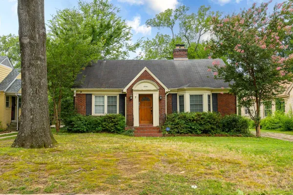 a view of a house with garden and trees