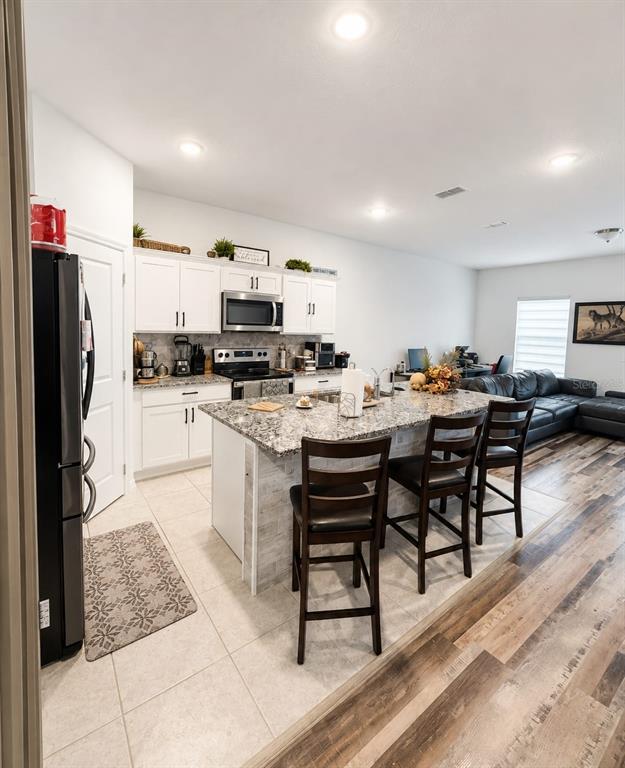 5882 Herder Road St. Cloud, FL 34771 - Photo 5 of 14 a kitchen with a sink a stove a refrigerator and chairs