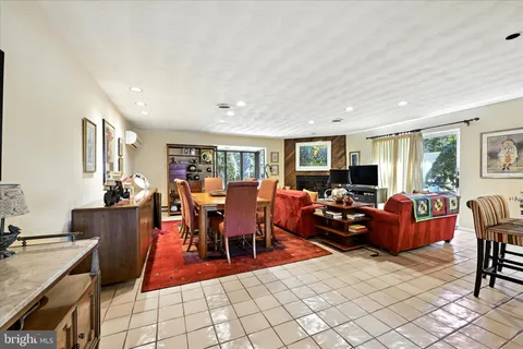 a living room with furniture a dining table and chairs with wooden floor