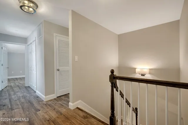 a view of a hallway with wooden floor and stairs