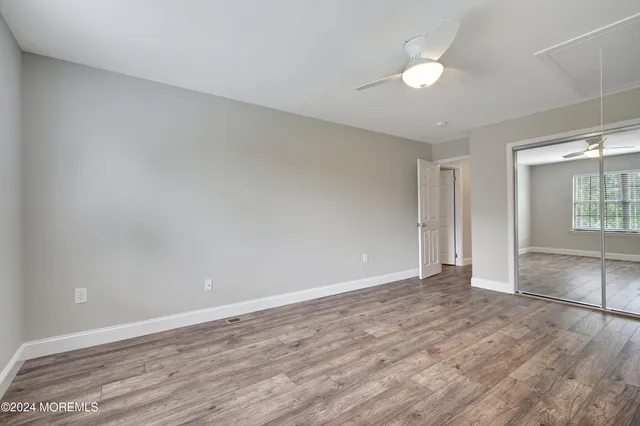 an empty room with wooden floor and window