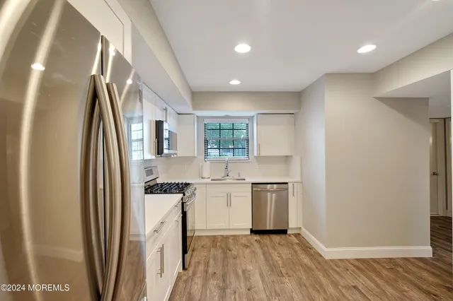 a kitchen with stainless steel appliances granite countertop a refrigerator and a sink
