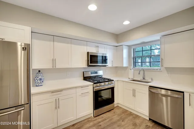 a kitchen with white cabinets and white appliances