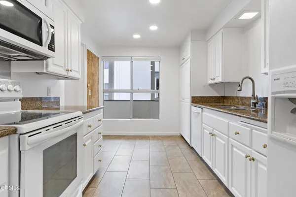 a kitchen with stainless steel appliances granite countertop a sink and cabinets