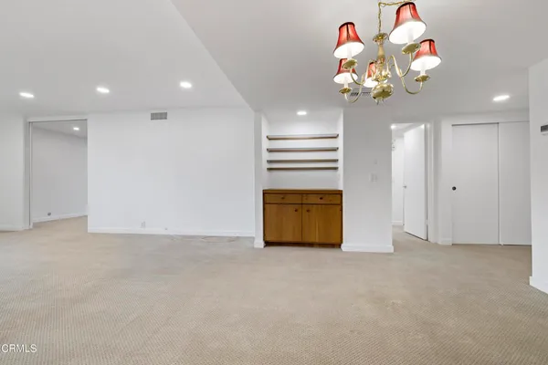 a view of a kitchen with furniture and an empty room