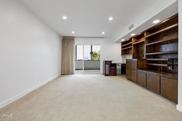 a view of an empty room with window and cabinet