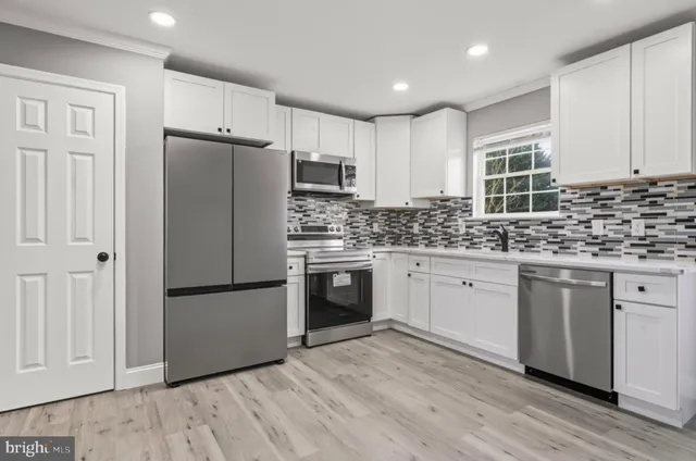 a kitchen with stainless steel appliances granite countertop a refrigerator sink and cabinets