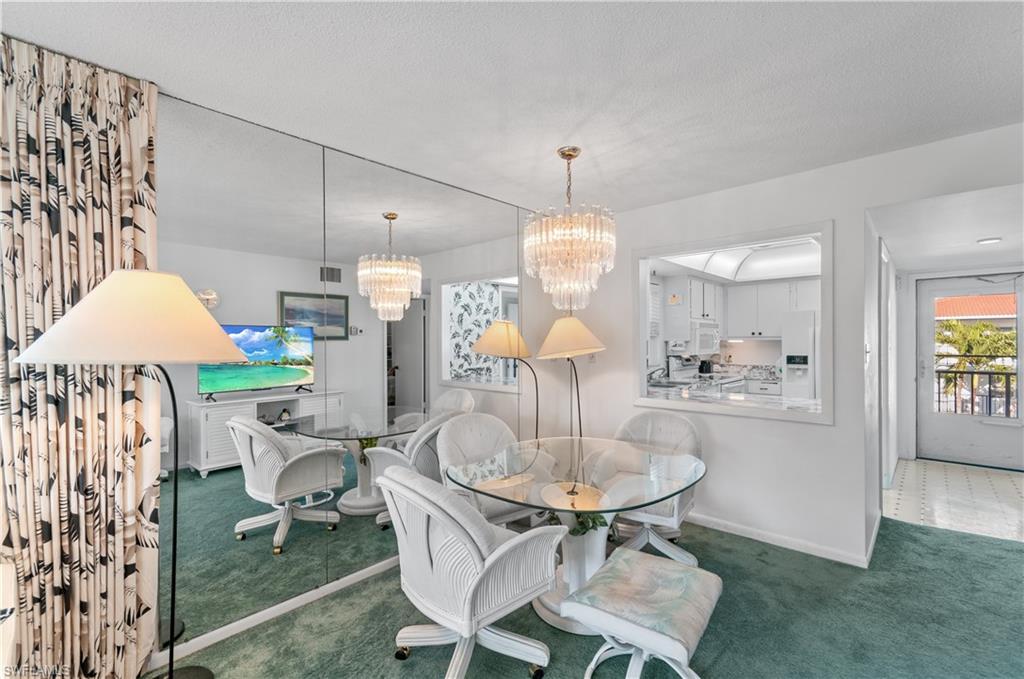 5 High Point Circle West, Unit 301 Naples, FL 34103 - Photo 12 of 37 a kitchen with a dining table and chairs
