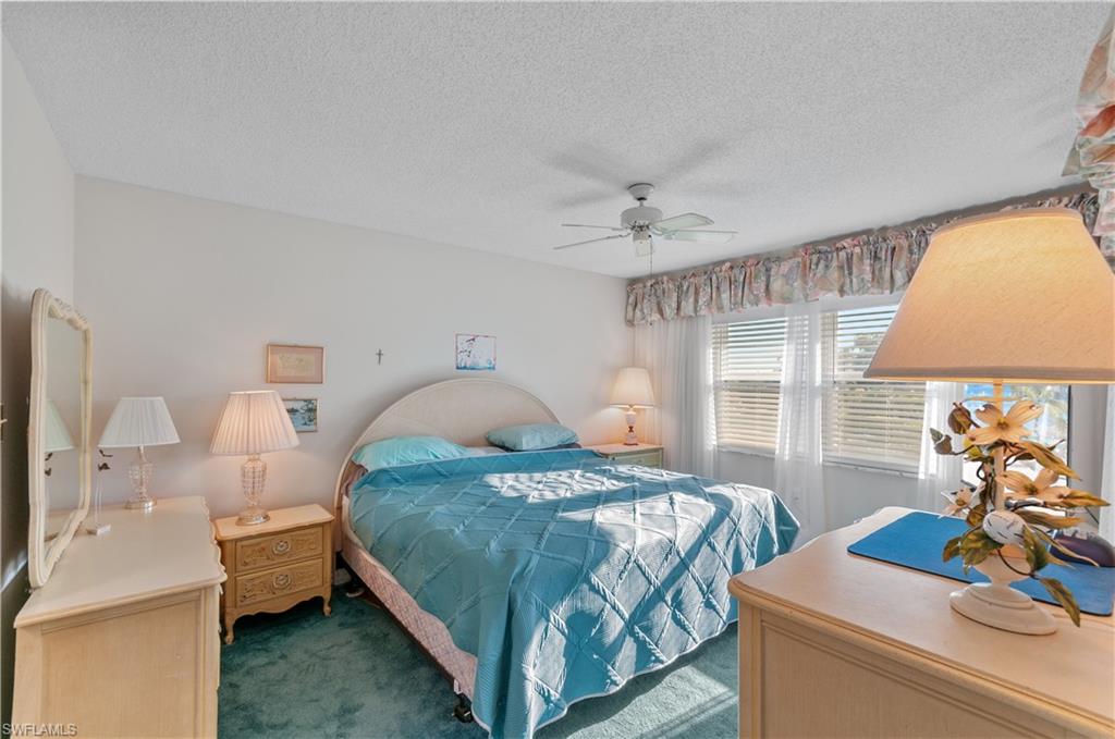 5 High Point Circle West, Unit 301 Naples, FL 34103 - Photo 14 of 37 a bedroom with a bed and large windows