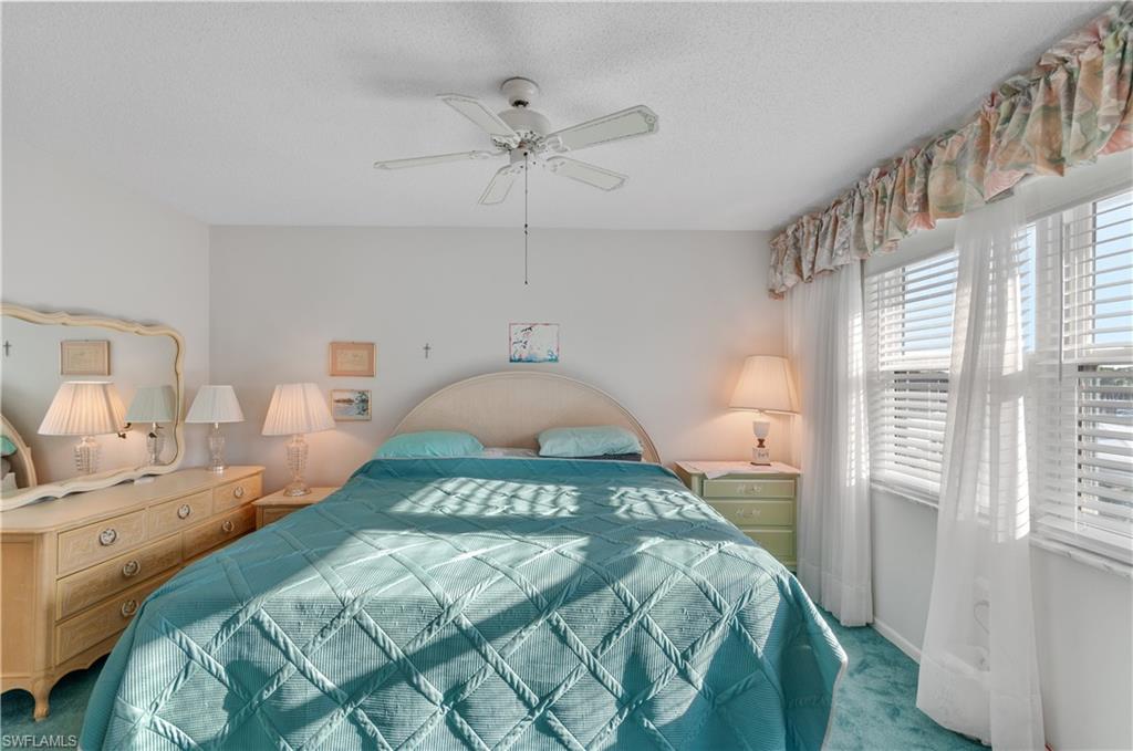 5 High Point Circle West, Unit 301 Naples, FL 34103 - Photo 21 of 37 a bedroom with a bed and a window