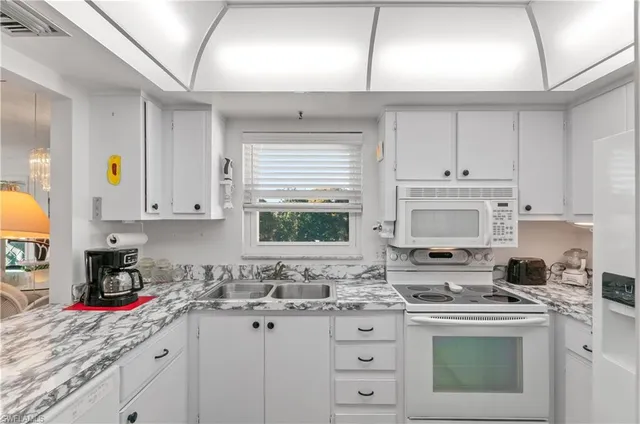 a kitchen with granite countertop a sink stove and cabinets