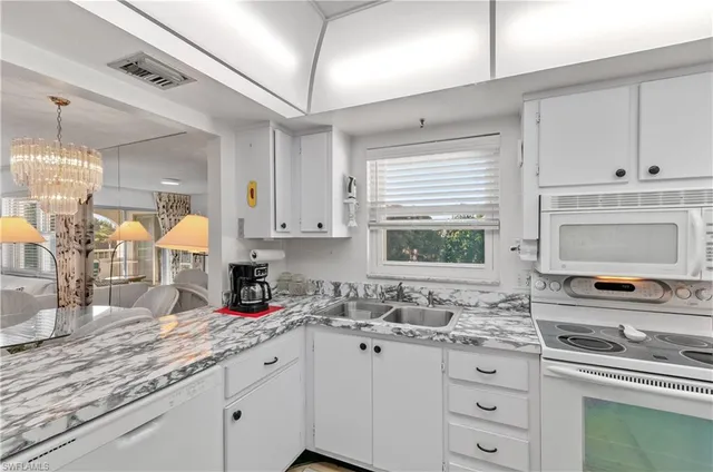 a kitchen with granite countertop a sink cabinets and window