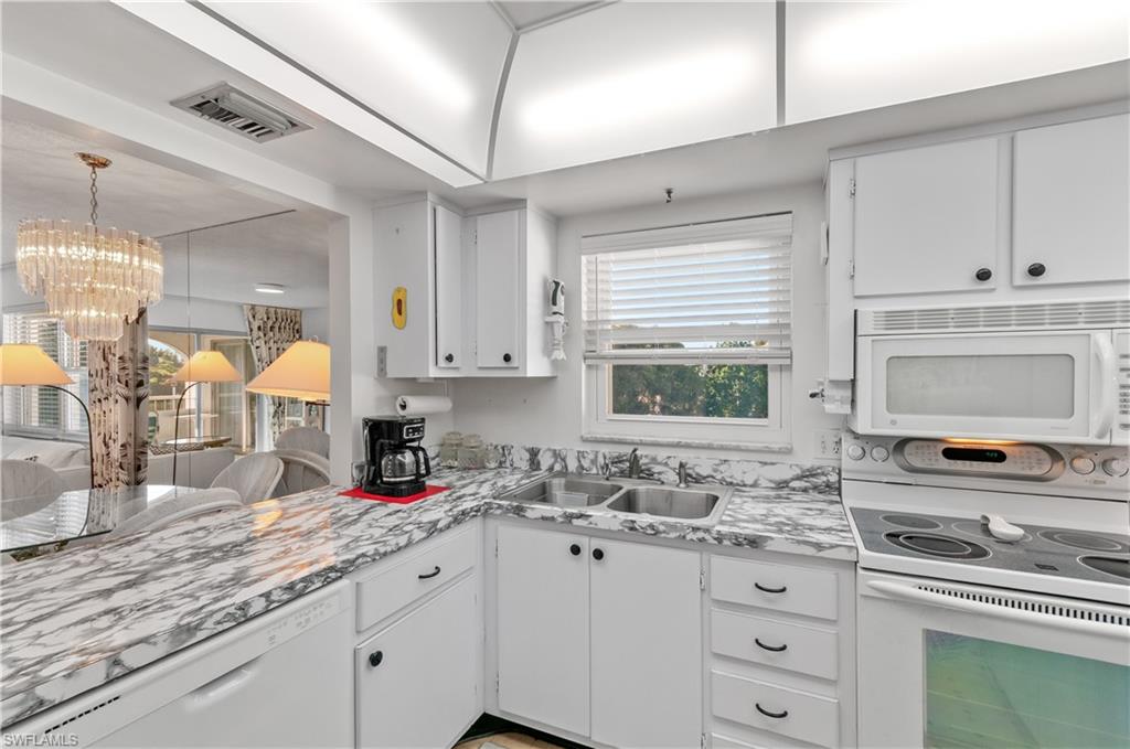 5 High Point Circle West, Unit 301 Naples, FL 34103 - Photo 7 of 37 a kitchen with granite countertop a sink cabinets and window