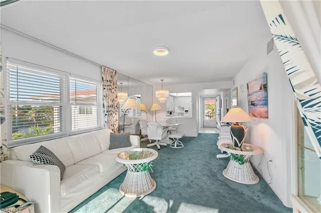 a living room with furniture chandelier and a large window