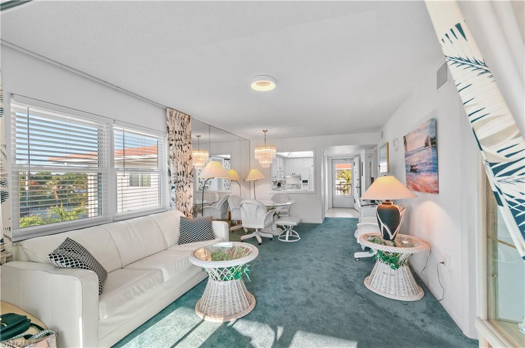 5 High Point Circle West, Unit 301 Naples, FL 34103 - Photo 9 of 37 a living room with furniture chandelier and a large window