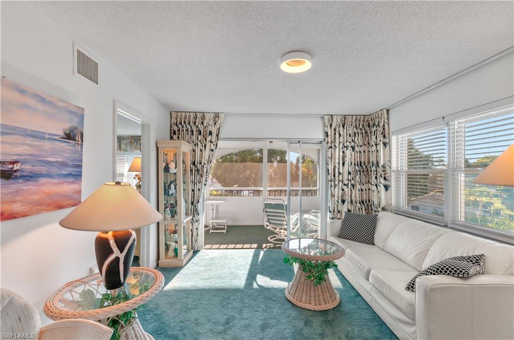 5 High Point Circle West, Unit 301 Naples, FL 34103 - Photo 10 of 37 a living room with furniture and a large window
