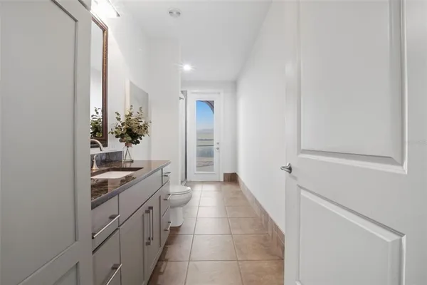 a bathroom with a granite countertop sink a toilet and shower
