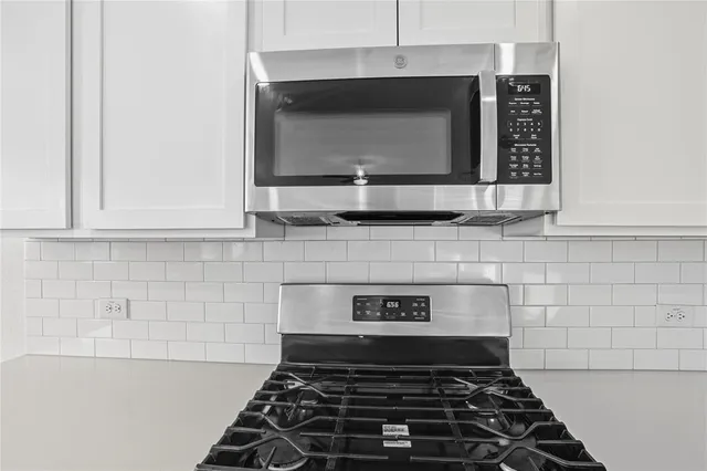 a kitchen with stainless steel appliances a sink a stove a microwave and cabinets