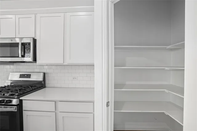 a kitchen with kitchen island a stove a sink and a microwave