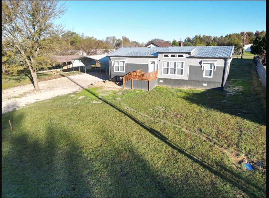 a view of a house with a yard and sitting area