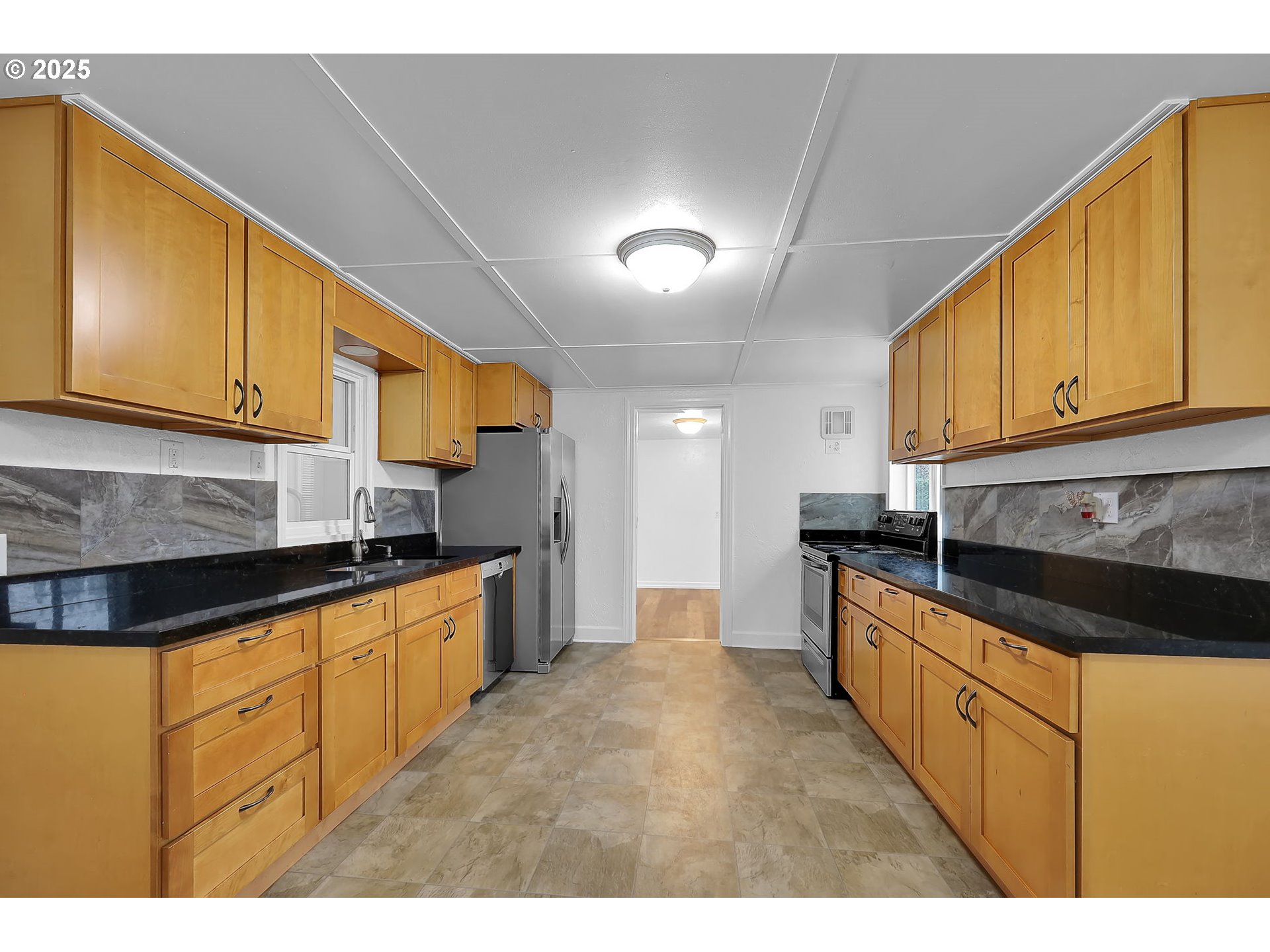 1349 E Street Springfield, OR 97477 - Photo 8 of 35 a kitchen with stainless steel appliances granite countertop a sink a stove cabinets and a refrigerator