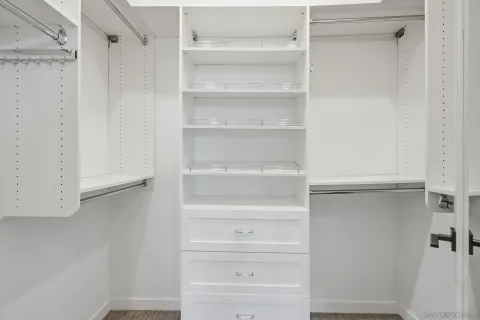 a view of walk in closet with empty racks